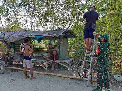 Babinsa Koramil 0826-11 Batumarmar Bantu Warga Rawat lampu jalan Dusun Barat Laok