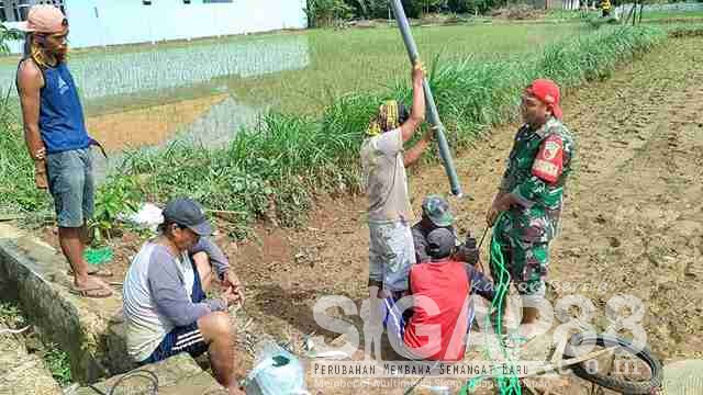 Babinsa Somalang Bantu Warga Pasang Pompa Sibel untuk Irigasi Sawah