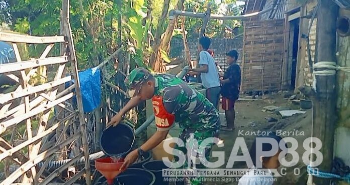 distribusi air bersih Dampak Kekeringan, Babinsa Koramil 0826-02 Tlanakan Bantu Pendistribusian Air Bersih di Desa Bandaran