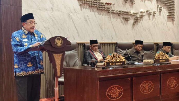 Wabup Sumenep saat rapat Wakil Bupati Sumenep KH Imam Hasyim menyampaikan Nota Penjelasan Raperda Pertanggungjawaban APBD 2025 dalam rapat paripurna DPRD Sumenep.