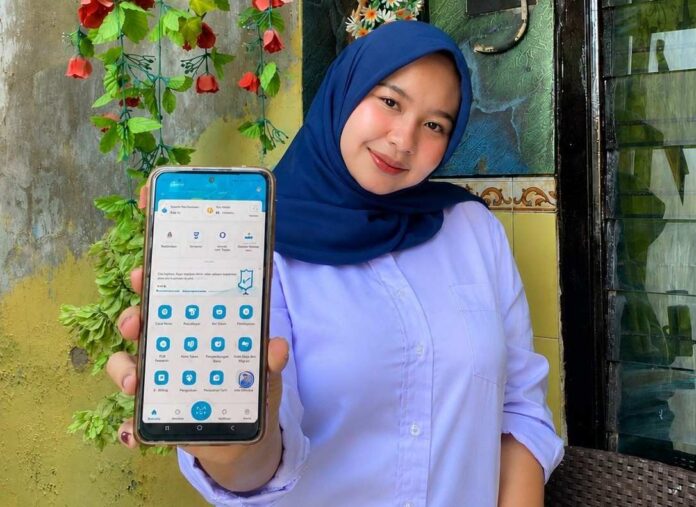 pelanggan PLN tunjukkan penggunaan aplikasi mobile PLN
