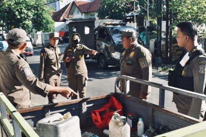 Petugas Satpol PP kota Surabaya saat melakukan penertiban di Jalan Nias