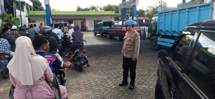 polisi-atur-antrean-bbm-spbu-ganding Polisi mengatur antrean kendaraan di SPBU Ganding Sumenep saat terjadi antrean BBM akibat pasokan Pertalite berkurang.